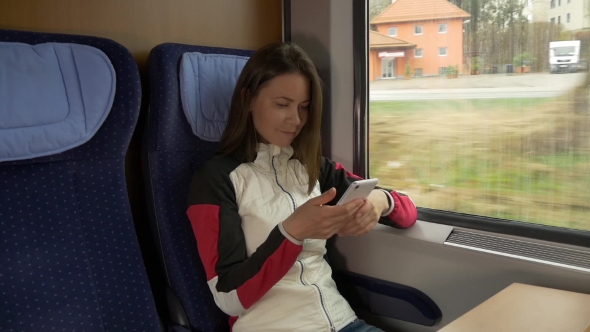 Woman Typing Sms on the Mobile Phone in a Train