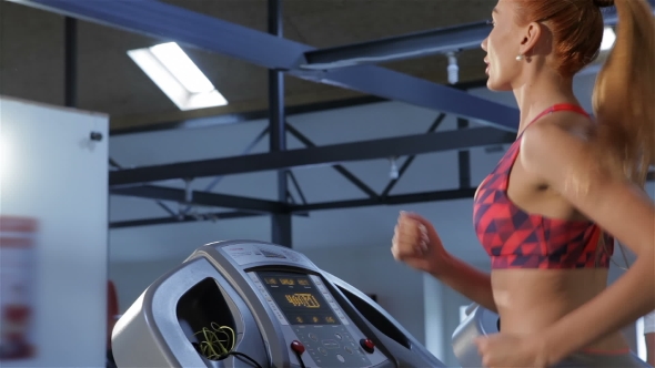 Woman Increases the Speed of Treadmill at the Fitness Centre alt