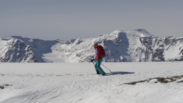 Female Trekker Walks on Top of Snowy Mountain