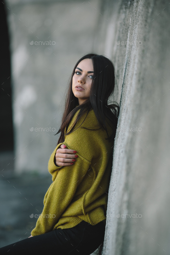 Young woman posing against a wall, thoughtful concept Royalty-Free Stock  Image - Storyblocks