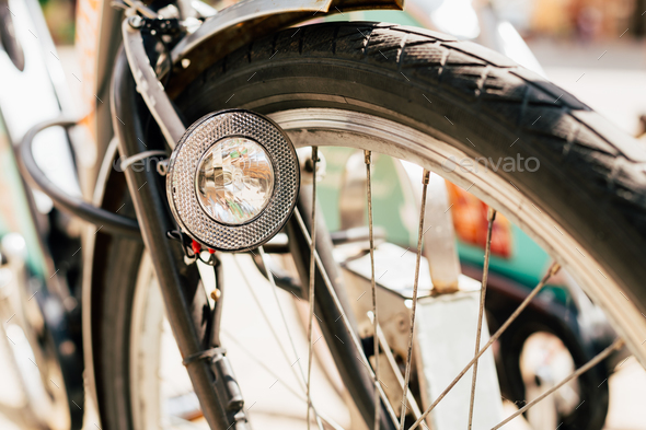 Close Up Of Bike Headlight And Wheel Of Bicycle On Street. Bike