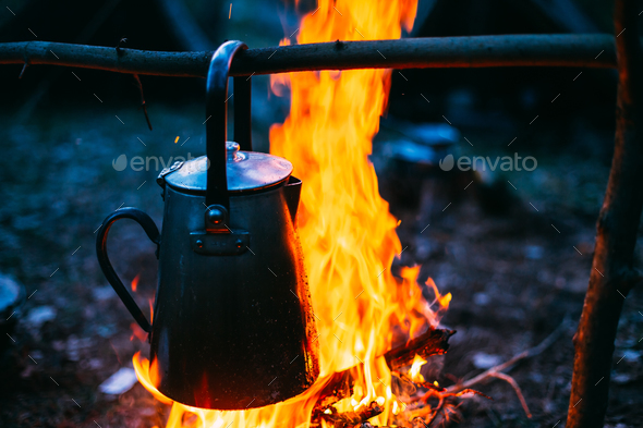 Old Iron Camp Kettle Boils Water On A Fire In Forest. Bright Fla