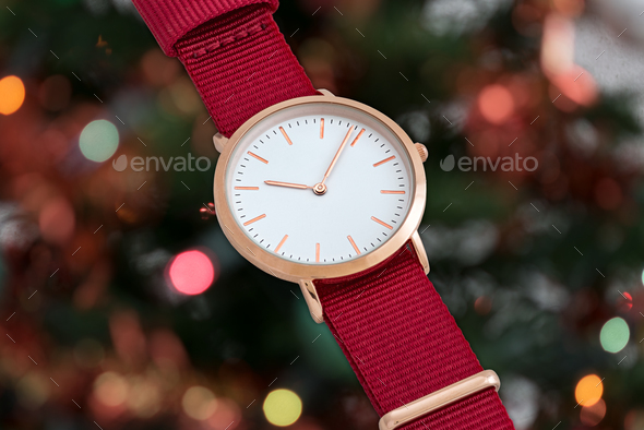Red nylon strap wrist watch in front of Christmas lights