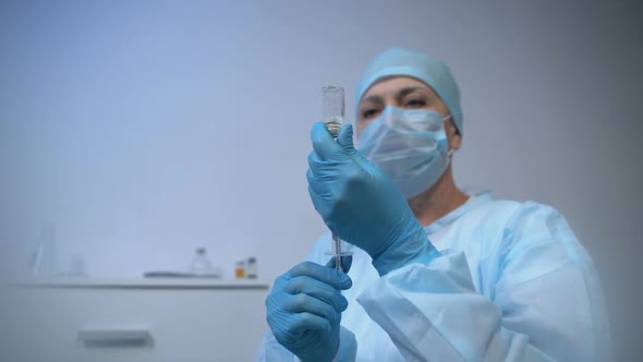 Female Doctor Taking Medicine Into Syringe and Making Injection to Patient