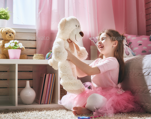 girl plays with teddy bear