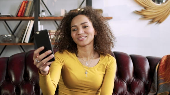 Young Happy Latin Woman Using Mobile Phone for Video Chat Online and Blogging for Social Media