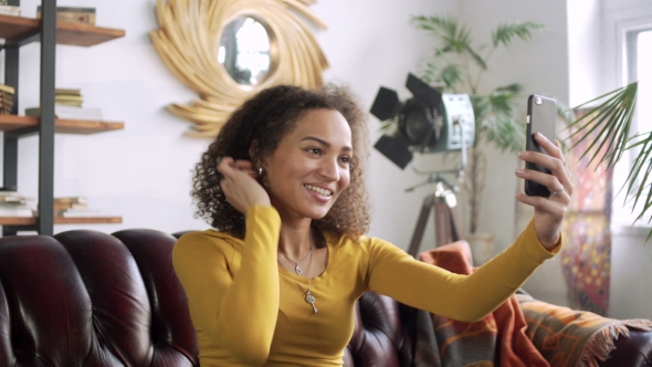 Young Happy Latin Woman Using Mobile Phone for Video Chat Online and Blogging for Social Media