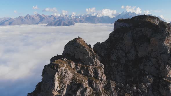 Aerial Shot of Climbers on Top of a Mountain High Above the Clouds