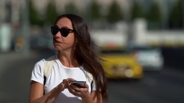 Female Tourist Is Orienting in New City By Map in Smartphone, Using Navigator at Mobile Phone alt