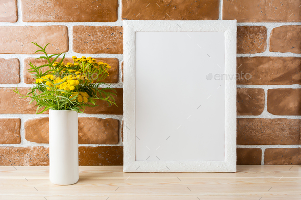 White frame mockup with yellow flowers near exposed brick walls - Stock Photo - Images