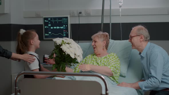 Little Girl and Woman Bringing Flowers to Visit Ill Patient alt