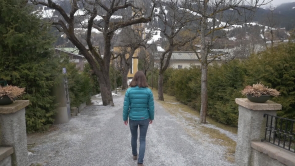 Woman Walking in Empty Park Towards Church