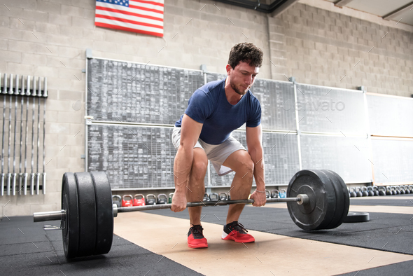 Athlete starting a deadlift in a crossfit gym - Stock Photo - Images