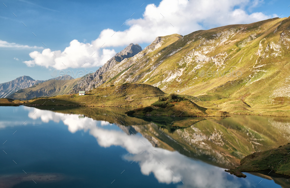 sky reflected in alpine lake - Stock Photo - Images
