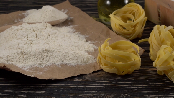 Pasta, Eggs, Oil and Flour on Wooden Background