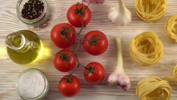 Pasta, Oil, Tomatos and Garlic on Wooden Background