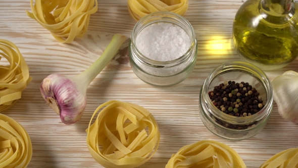 Pasta, Oil, Tomatos and Garlic on Wooden Background