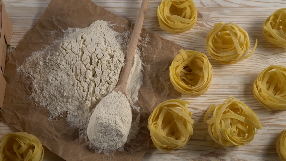 Pasta, Eggs and Flour on Wooden Background