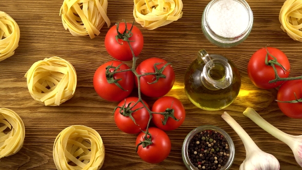 Pasta, Oil, Tomatos and Garlic on Wooden Background