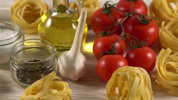 Pasta, Oil, Tomatos and Garlic on Wooden Background