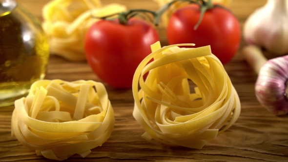 Pasta, Oil, Tomatos and Garlic on Wooden Background