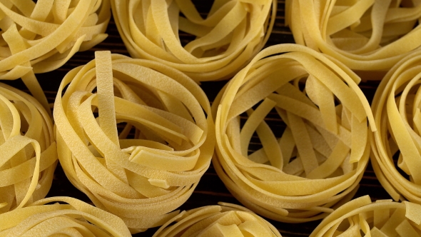 Raw Unprepared Pasta on Wooden Board.