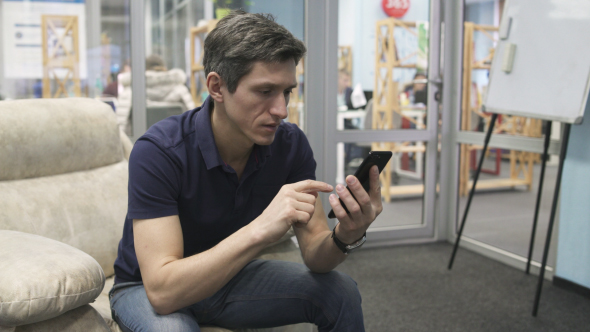 Man Using Black Smartphone in the Office