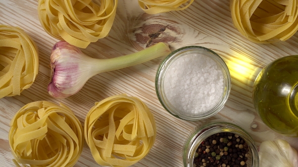 Pasta, Oil, Tomatos and Garlic on Wooden Background