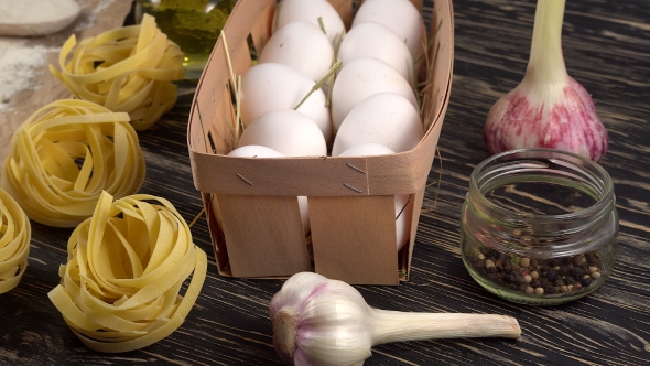 Pasta, Eggs ,Garlic, Oil and Flour on Wooden Background