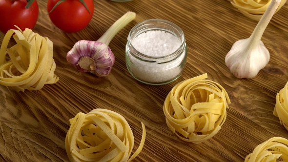 Pasta, Oil, Tomatos and Garlic on Wooden Background