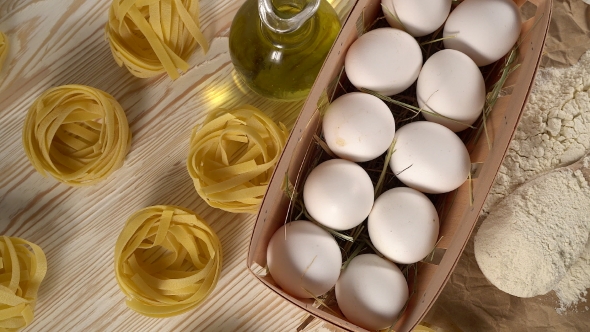 Pasta, Eggs, Oil and Flour on Wooden Background