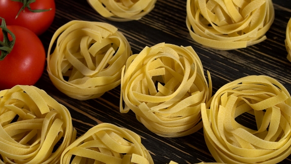 Pasta, Oil, Tomatos and Garlic on Wooden Background