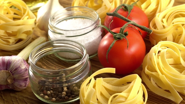 Pasta, Oil, Tomatos and Garlic on Wooden Background