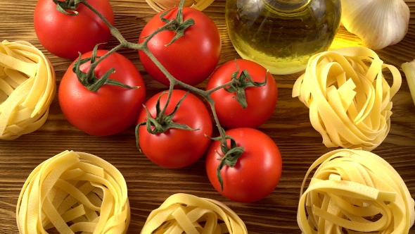 Pasta, Oil, Tomatos and Garlic on Wooden Background