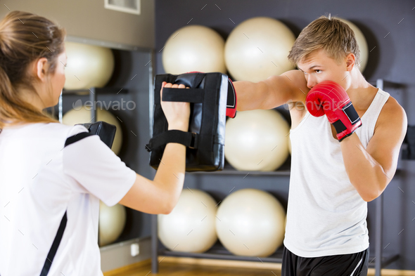 Dedicated Boxer Punching Bag Held By Instructor - Stock Photo - Images