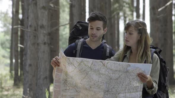 Hikers looking at map in woods alt