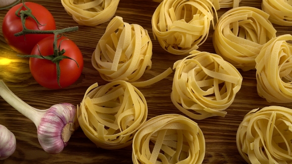 Pasta, Oil, Tomatos and Garlic on Wooden Background