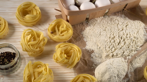 Pasta, Eggs, Oil, Garlic and Flour on Wooden Background