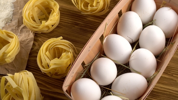 Pasta, Eggs and Flour on Wooden Background