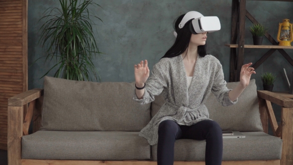 Woman Using a Virtual Reality Headset on Sofa at Home alt