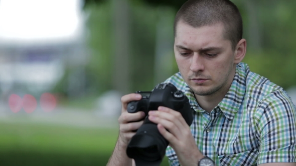 Young Man Taking Pictures At A Professional Digital Slr Camera