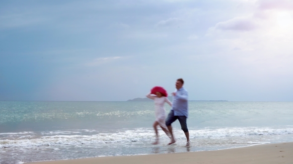Man and a Girl Running Along the Beach alt
