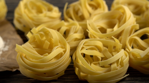 Pasta and Flour on Wooden Background