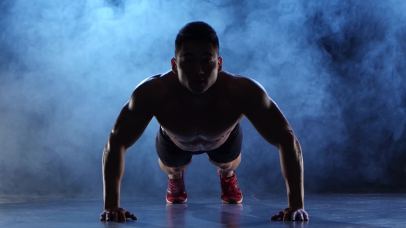 Asian Bodybuilder Man Push Ups. Black Smoke Background. Silhouette alt