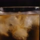 Closeup of a Full Glass of Whiskey with Ice Slowly Rotates on a Black Background - VideoHive Item for Sale