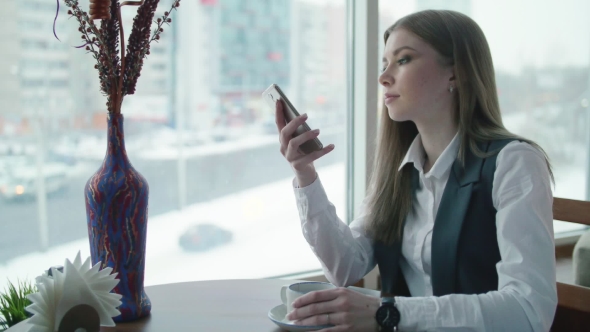 One Business Woman Is Sitting in a Cafe and Smiling and Talking on the Phone