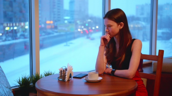 One Business Woman Is Sitting in a Cafe and Smiling and Talking on the Phone