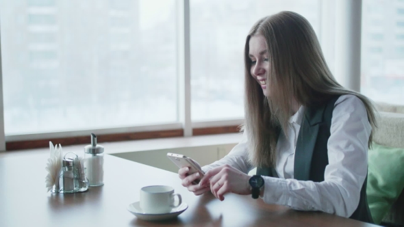 One Business Woman Is Sitting in a Cafe and Smiling and Talking on the Phone