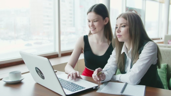 Two Business Women Talk about Work in Cafe