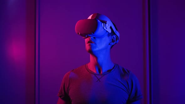 Young Man Watches 360 Media Content in VR Helmet alt